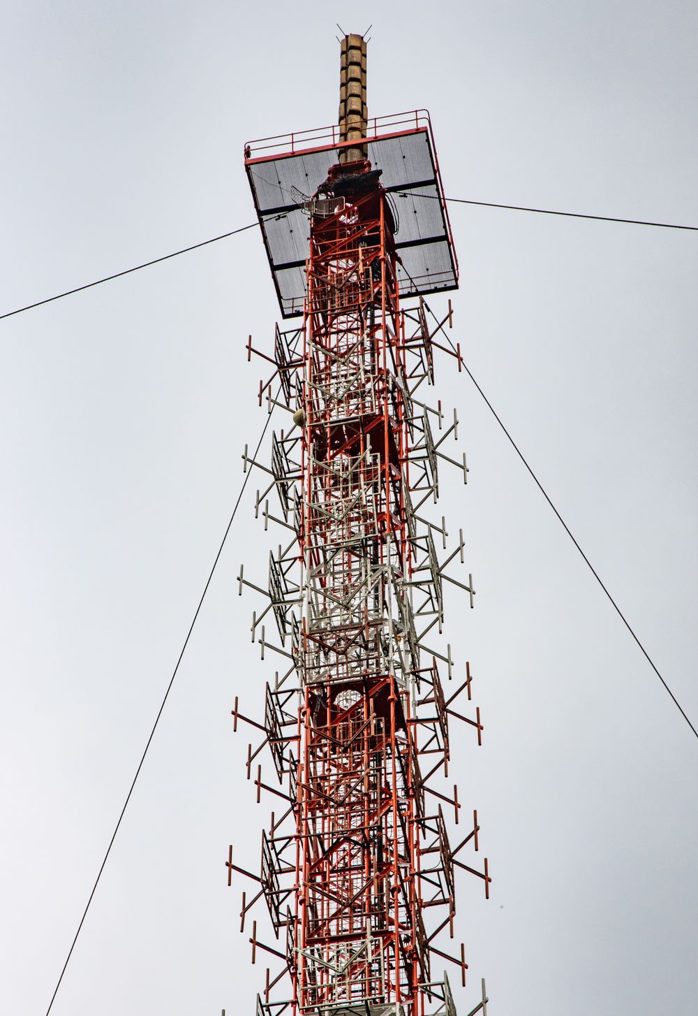 Omroepzendmast met antennes tegen een lichte lucht.