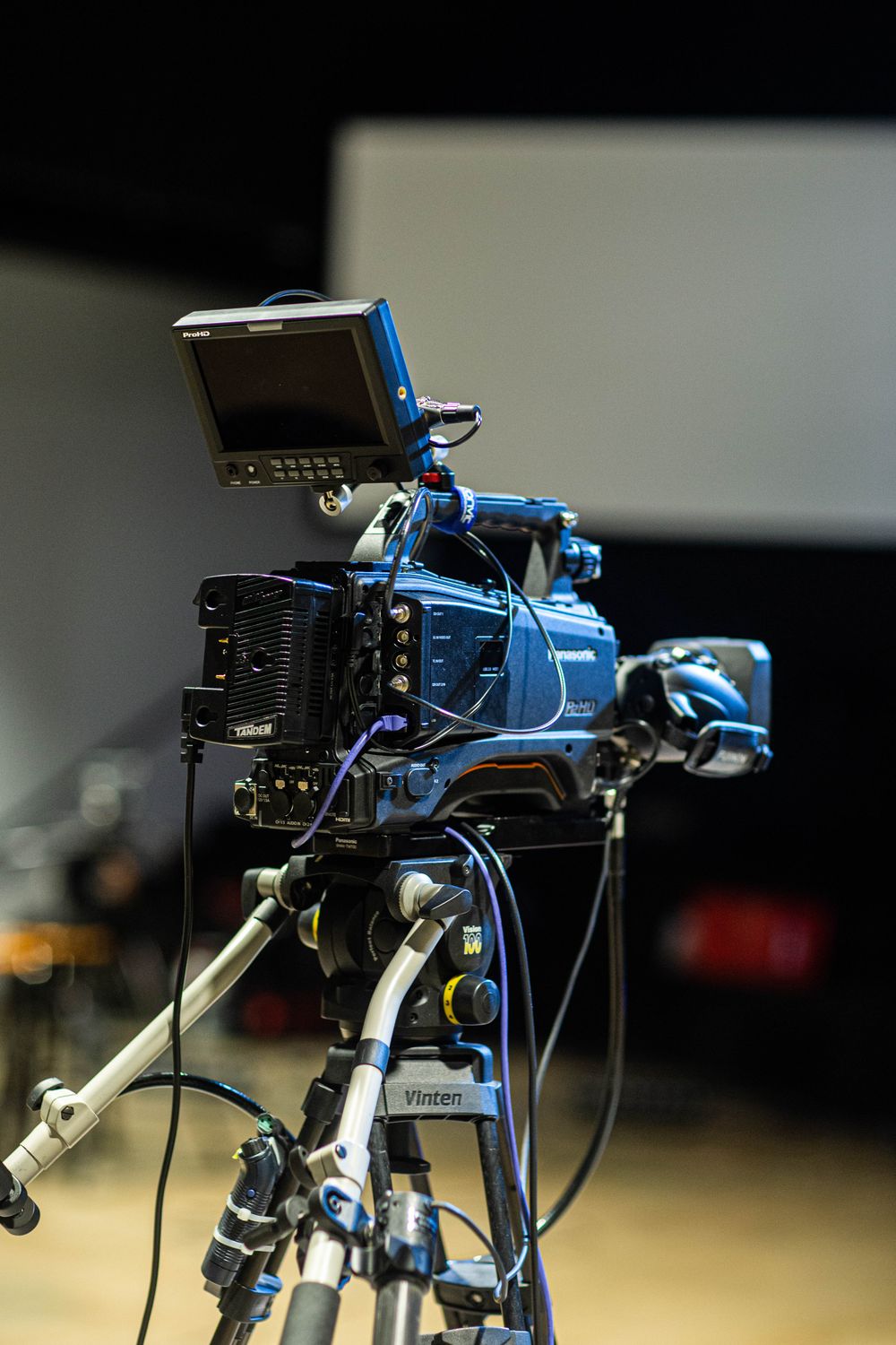 Een professionele videocamera op een statief in een studio.